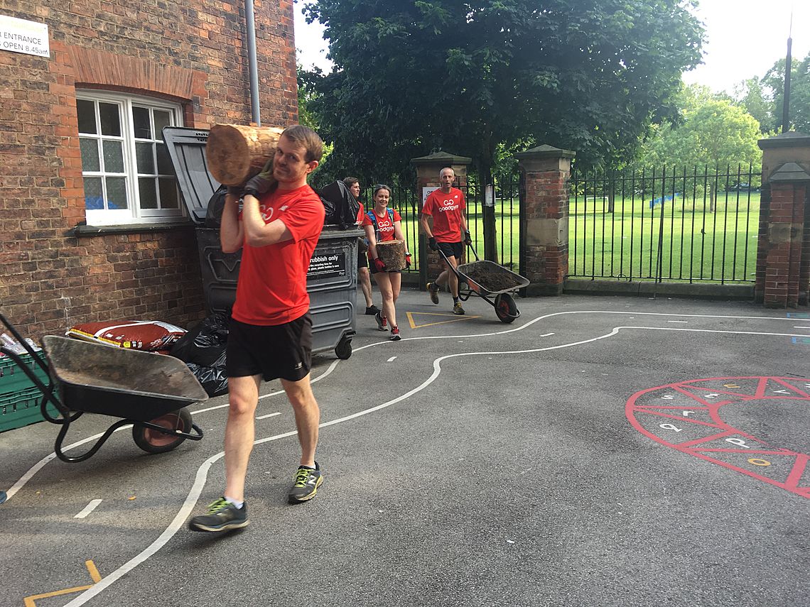 GoodGym members complete a task, carrying logs and wheelbarrows
