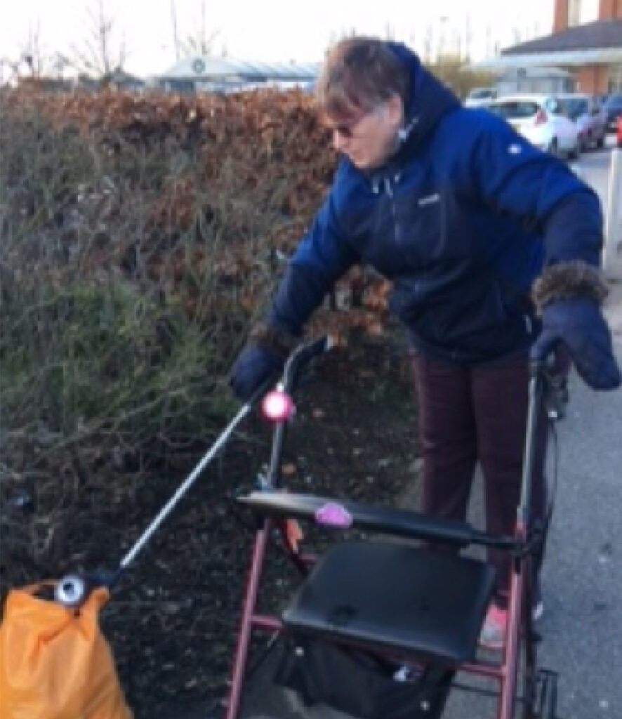 A woman picking up litter while getting out as part of a Move Mates project.